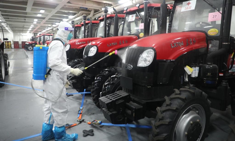A staff member disinfects tractors on a ship delivering relief supplies to Tonga, Jan. 28, 2022. (Photo by Wang Lei/Xinhua)