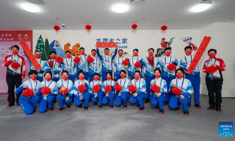 Volunteers pose for a group photo at the Olympic Village for the Beijing 2022 Winter Olympics in Yanqing District of Beijing, capital of China, Jan. 31, 2022. Delegation members and volunteers celebrated the Chinese Lunar New Year, or the Year of Tiger at the Olympic Village on Monday. (Photo by Meng Yuhao/Xinhua)