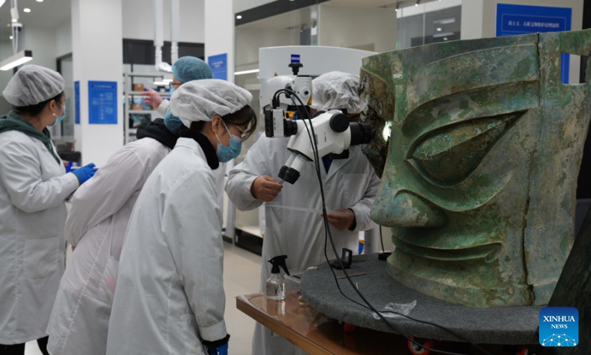 File photo shows staff members repairing the bronze mask discoverd at the Sanxingdui Ruins site in southwest China's Sichuan Province. The largest bronze mask unearthed from the legendary Sanxingdui Ruins site in Sichuan met the public at Monday's Spring Festival TV Gala. (National Cultural Heritage Administration/Handout via Xinhua)