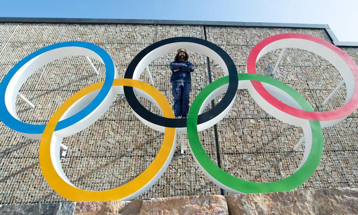Carlo Valdes, a member of the US team to the 2022 Winter Olympics, poised for a photo with five rings of the Olympic symbol. Photo: Courtesy of Valdes