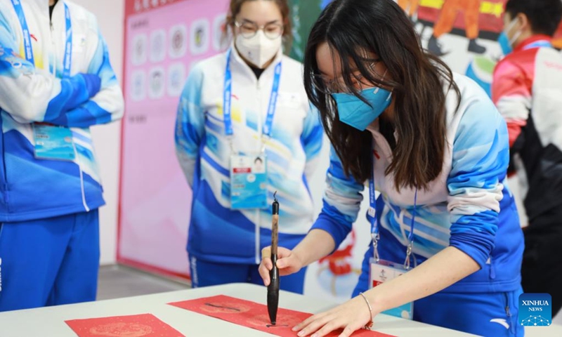 A volunteer writes Spring Festival couplets at the Olympic Village for the Beijing 2022 Winter Olympics in Yanqing District of Beijing, capital of China, Jan. 31, 2022. Delegation members and volunteers celebrated the Chinese Lunar New Year, or the Year of Tiger at the Olympic Village on Monday. (Photo by Xiao Shaowen/Xinhua)
