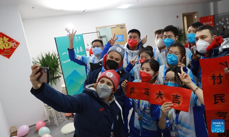 Delegation members of Serbia and volunteers pose for selfies at the Olympic Village for the Beijing 2022 Winter Olympics in Yanqing District of Beijing, capital of China, Jan. 31, 2022. Delegation members and volunteers celebrated the Chinese Lunar New Year, or the Year of Tiger at the Olympic Village on Monday. (Photo by Xiao Shaowen/Xinhua)