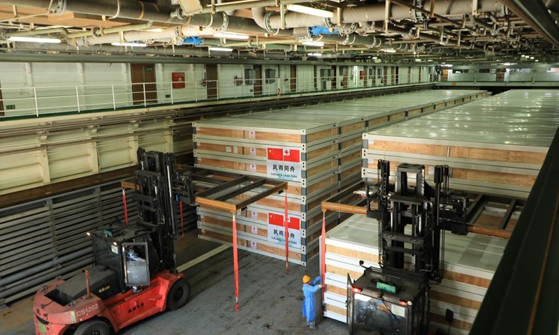 Relief supplies are transferred onto a ship waiting to depart for Tonga, in Guangzhou, south China's Guangdong Province, Jan. 30, 2022. (Photo by Xue Chengqing/Xinhua)