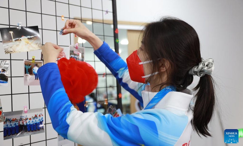 A volunteer hangs a red lantern at the Olympic Village for the Beijing 2022 Winter Olympics in Yanqing District of Beijing, capital of China, Jan. 31, 2022. Delegation members and volunteers celebrated the Chinese Lunar New Year, or the Year of Tiger at the Olympic Village on Monday. (Photo by Xiao Shaowen/Xinhua)