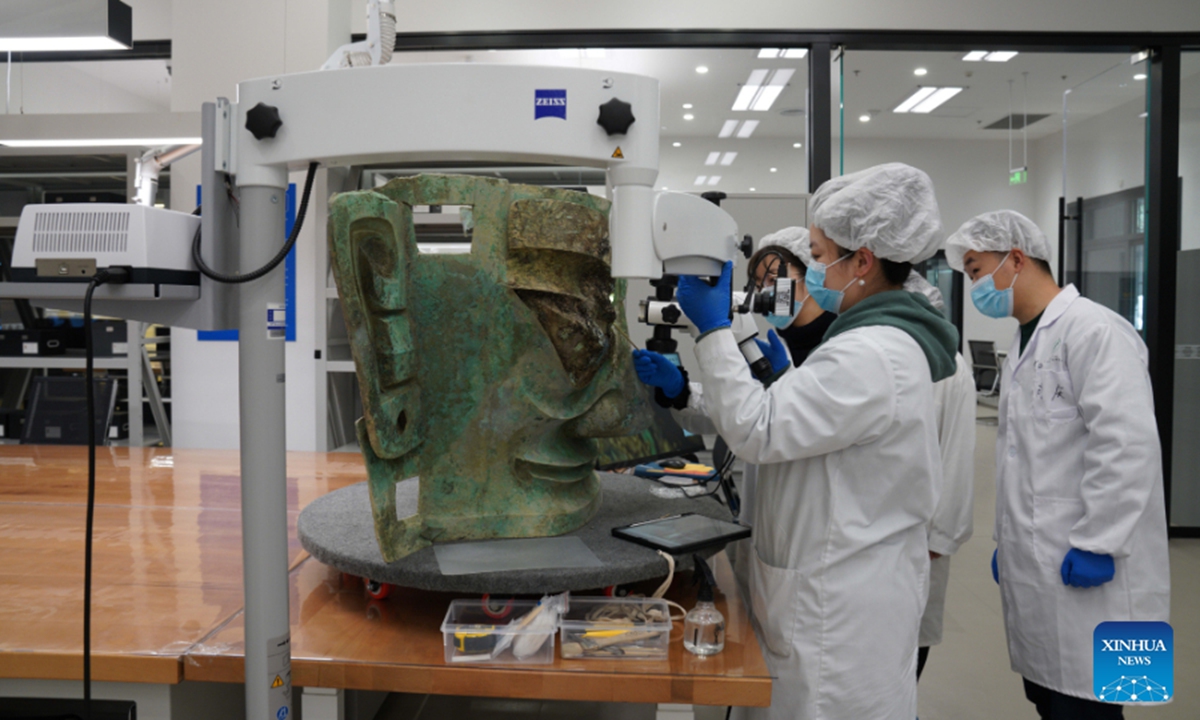 File photo shows staff members repairing the bronze mask discoverd at the Sanxingdui Ruins site in southwest China's Sichuan Province. The largest bronze mask unearthed from the legendary Sanxingdui Ruins site in Sichuan met the public at Monday's Spring Festival TV Gala. (Sichuan Provincial Cultural Relics and Archaeology Research Institute & Sanxingdui Museum/Handout via Xinhua)