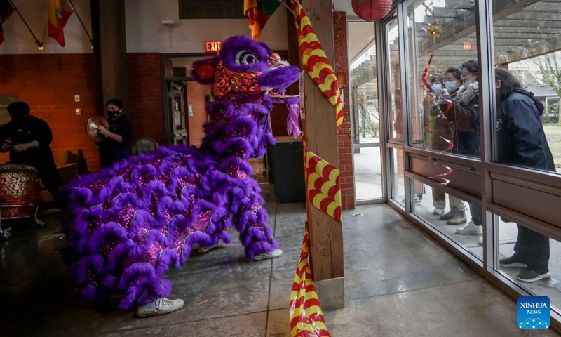 People watch a lion dance from outside through the windows at St. John's College, the University of British Columbia, in Vancouver, British Columbia, Canada, on Feb. 3, 2022.Photo:Xinhua