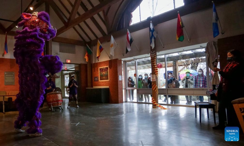 A woman films a lion dance at St. John's College, the University of British Columbia, in Vancouver, British Columbia, Canada, on Feb. 3, 2022.Photo:Xinhua