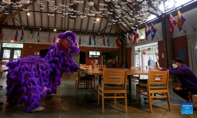 A man live-streams a lion dance at St. John's College, the University of British Columbia, in Vancouver, British Columbia, Canada, on Feb. 3, 2022.Photo:Xinhua