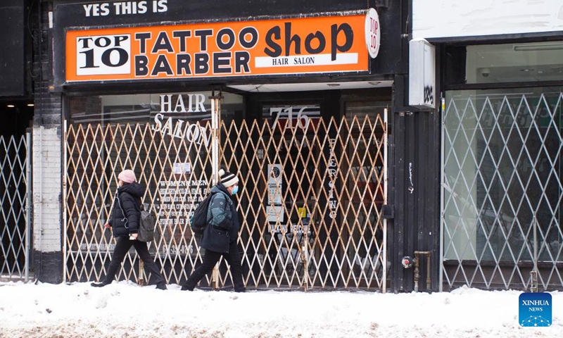 People walk past a closed hair salon in Toronto, Canada, on Feb. 4, 2022.Photo:Xinhua