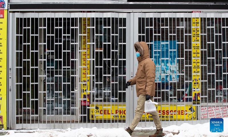 A man wearing a face mask walks past a closed store in Toronto, Canada, on Feb. 4, 2022.Photo:Xinhua