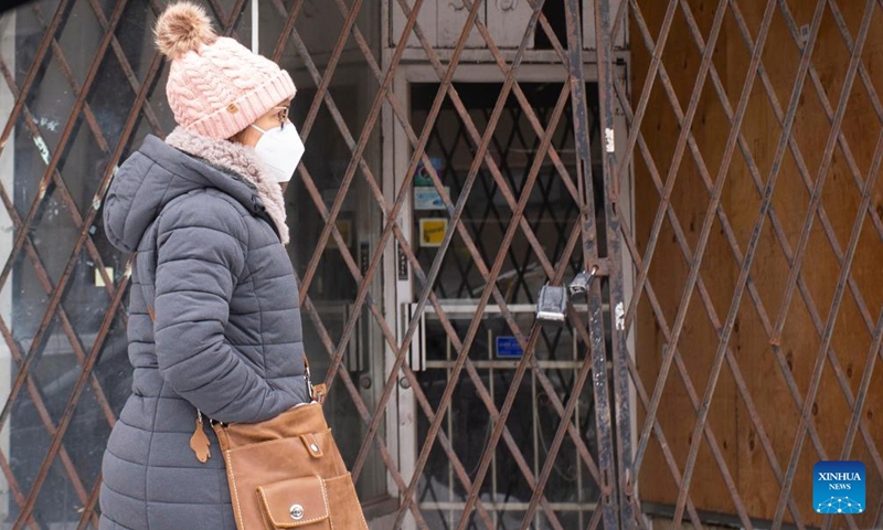 A woman wearing a face mask walks past a closed store in Toronto, Canada, on Feb. 4, 2022.Photo:Xinhua