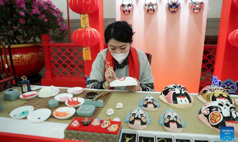 A craftswoman demonstrates the art of Chinese opera face painting during the China Intangible Cultural Heritage Demonstration at the Great Hall of the People in Beijing, capital of China, Feb. 5, 2022. Photo: Xinhua