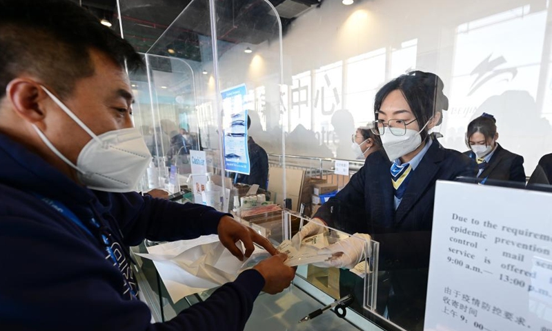 A customer buys the first day cover of commemorative stamps for the opening of the 24th Olympic Winter Games at the temporary post office of the Main Media Center for the Beijing 2022 Olympic and Paralympic Winter Games in Beijing, capital of China, Feb. 5, 2022.Photo:Xinhua
