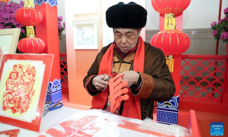 A craftsman makes paper-cut artworks during the demonstration of China's intangible cultural heritage at the Great Hall of the People in Beijing, capital of China, Feb. 5, 2022. Photo: Xinhua