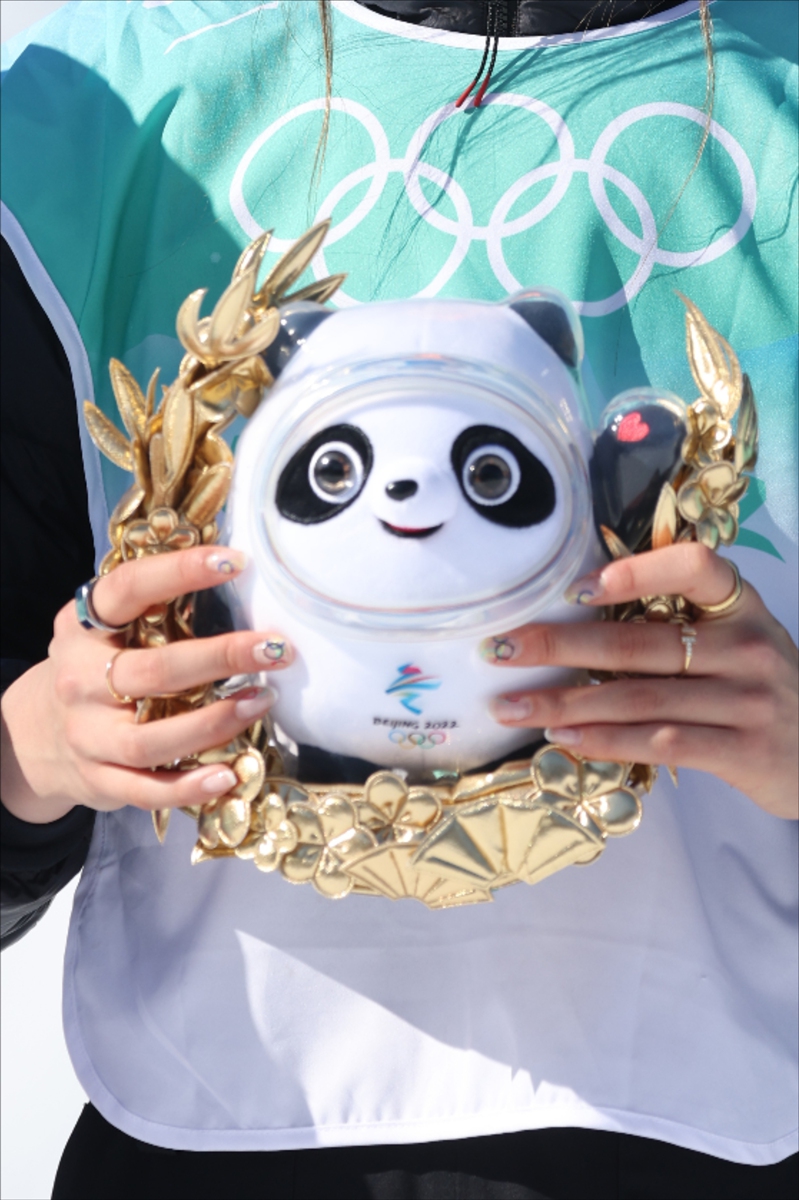 Gu Ailing holds the Beijing 2022 mascot on the podium on February 8, with her 