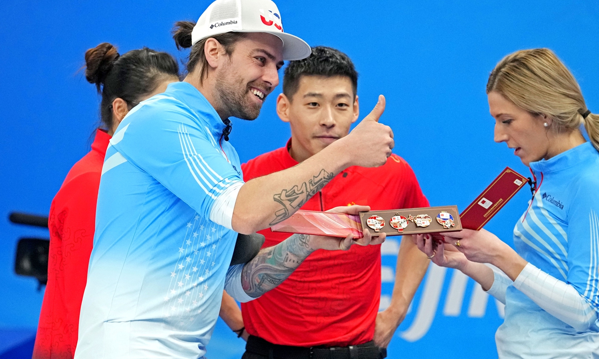 American curlers Chris Plys (left) and Victoria Persinger (right) receive gifts from their Chinese rivals Ling Zhi and Fan Suyuan on February 5 in Beijing. Photo: IC