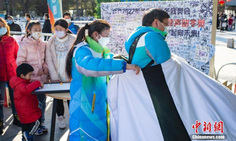 A student volunteer (Right) from Taiwan and studying at Minzu University of China wears the costume of the mascot Bing Dwen Dwen to echo the ongoing Beijing 2022 Winter Olympics at Zizhuyuan Park in Beijing, Feb. 5, 2022. (Photo: China News Service/Hou Yu)