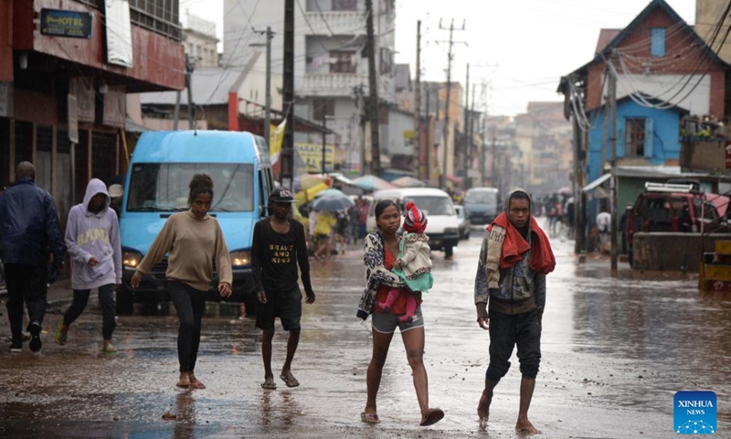 People walk on a flooded road in Antananarivo, Madagascar, on Feb. 6, 2022. A total of 20 deaths were recorded Monday in Madagascar by the Office of Risk and Disaster Management, following the passage of intense tropical cyclone Batsirai Saturday and Sunday.(Photo: Xinhua)