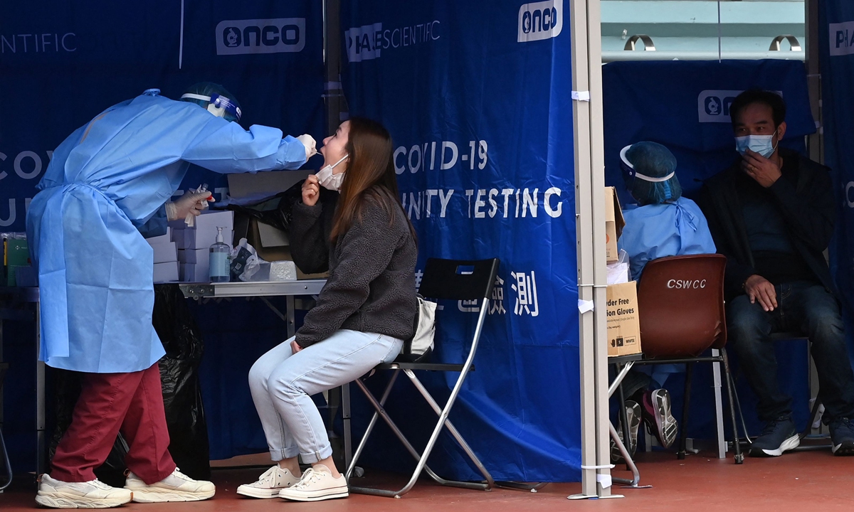 A woman is tested at a mobile specimen collection station for COVID-19 in Hong Kong's Prince Edward district on February 8, 2022, as authorities scrambled to ramp up testing capacity following a record high of new infections. Photo: VCG