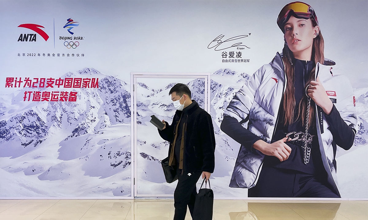 A man walks past an advertising poster of Chinese freestyle skier Gu Ailing at the APM shopping mall in Beijing on November 20, 2021. Photo: VCG