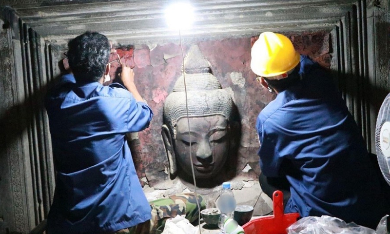 A recent photo shows staff members restoring a damaged Buddha statue at Bakan tower of the famed Angkor Wat in Siem Reap province, Cambodia, Feb. 8, 2022.Photo:Xinhua