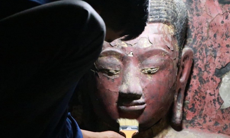 A recent photo shows a staff member restoring a damaged Buddha statue at Bakan tower of the famed Angkor Wat in Siem Reap province, Cambodia, Feb. 8, 2022.Photo:Xinhua
