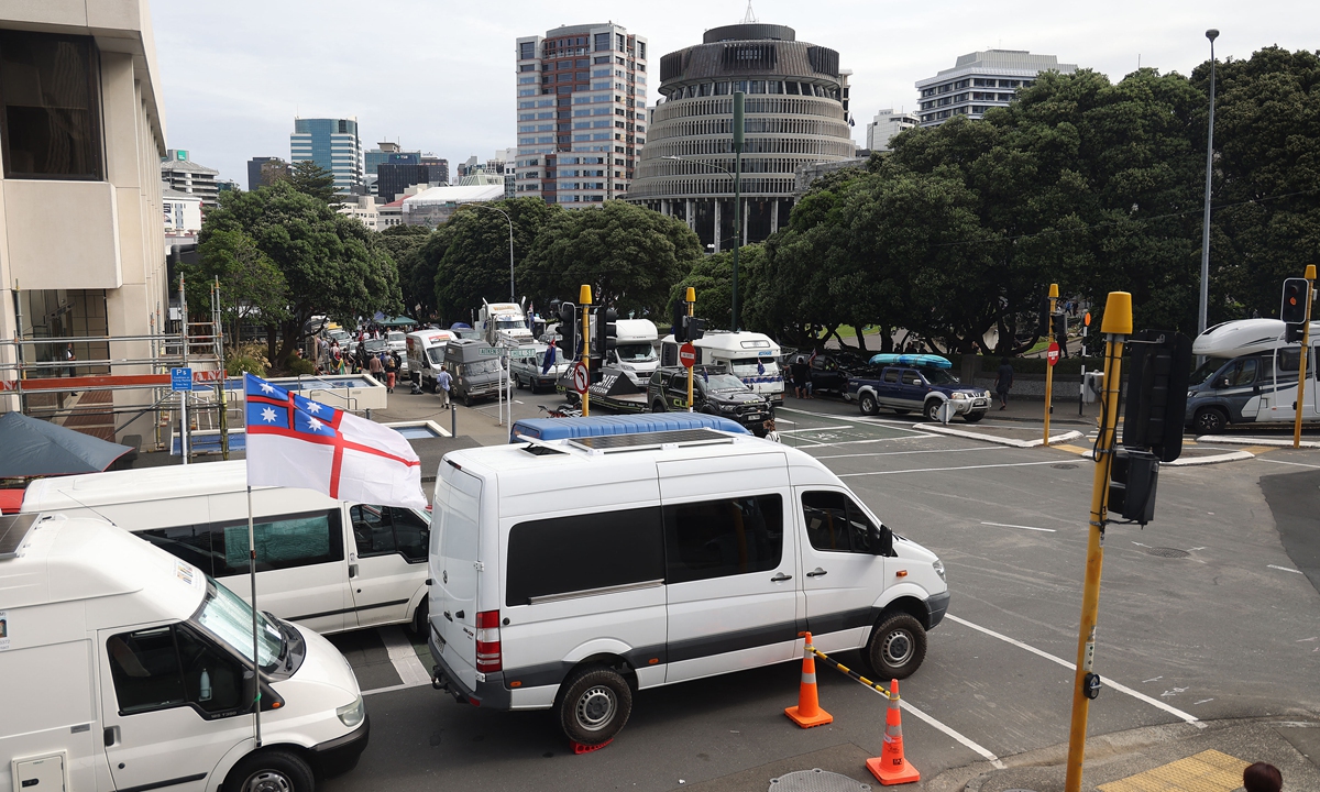 Vehicles block the streets around the parliament building, or The Beehive, (center behind) in Wellington, New Zealand on February 9, 2022, on the second day of the demonstration against COVID-19 restrictions, inspired by a similar one in Canada. Photo: AFP