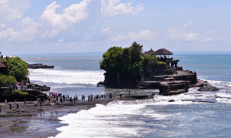 People visit Tanah Lot in Bali, Indonesia, Dec. 18, 2021.Photo:Xinhua