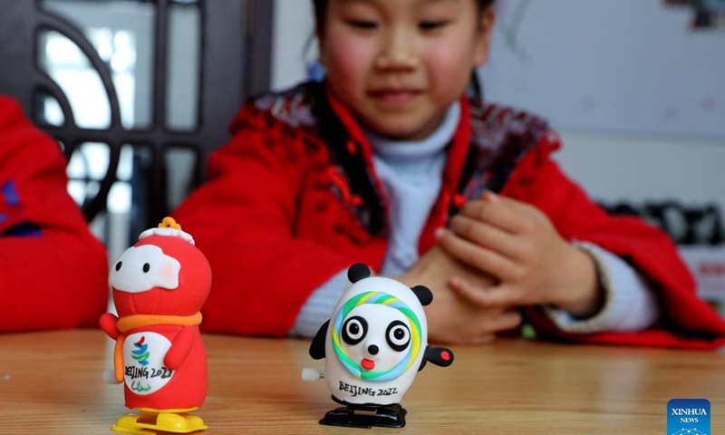 Children show self-made toys of Bing Dwen Dwen, the mascot for the Beijing 2022 Olympic Winter Games, and Shuey Rhon Rhon, the mascot of Beijing 2022 Paralympic Winter Games, at Xidu sub-district of Fengxian District in east China's Shanghai, Feb. 10, 2022. (Xinhua)