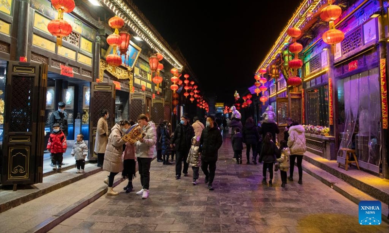 Tourists visit the Pingyao Ancient Town during the Spring Festival in Jinzhong City, north China's Shanxi Province, Feb. 7, 2022. With a history of over 2,800 years, Pingyao was named a world heritage site by UNESCO in 1997. It is best known for its almost intact Ming Dynasty (1368-1644) city walls and well-preserved architectures, and is a popular destination for both Chinese and overseas tourists. (Xinhua)