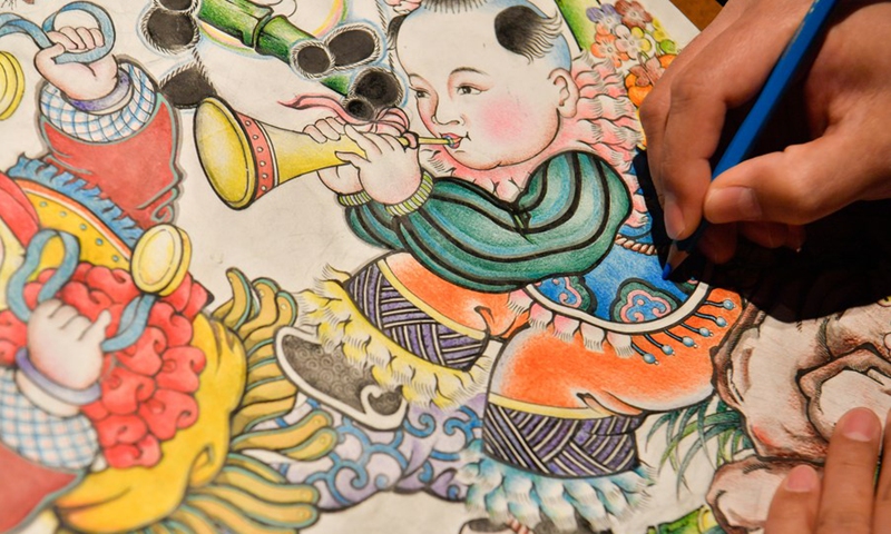 A member of a Yangliuqing woodblock painting team works on a piece of work in Tianjin, north China, Feb. 10, 2022.(Photo: Xinhua)
