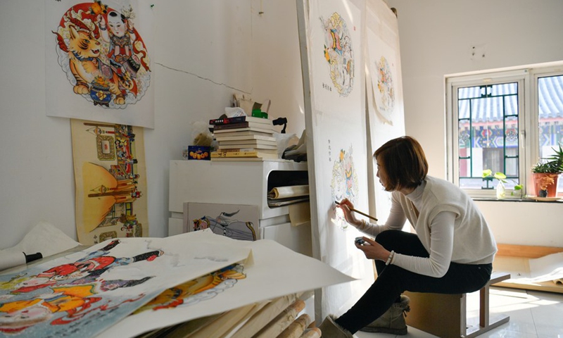 Wang Yan, a member of a Yangliuqing woodblock painting team, works on a piece of work in Tianjin, north China, Feb. 10, 2022.   (Photo: Xinhua)