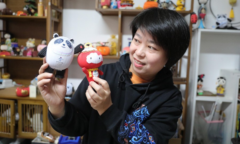 Li Xue shows a mascot of Beijing 2022 Olympic Winter Games Bing Dwen Dwen and a mascot of Beijing 2022 Paralympic Winter Games Shuey Rhon Rhon, both made of paper in Shenyang, capital of northeast China's Liaoning Province, Feb. 10, 2022.(Photo: Xinhua)