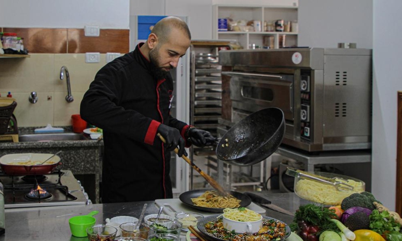 Ibrahim Badwan, a chef, prepares Chinese dishes at Mzaaq center for culinary arts education, in Gaza City, Feb. 6, 2022.Photo:Xinhua