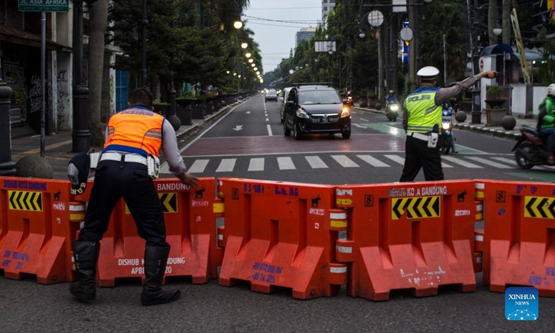 Officers from transportation department set up road blocks during a large-scale social restriction for crowd in Bandung, West Java, Indonesia, Feb. 13, 2022.Photo:Xinhua