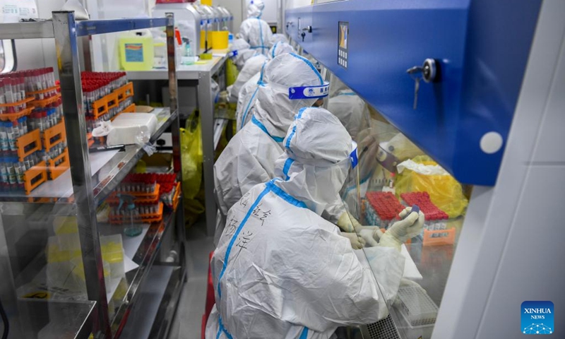 Medical workers handle COVID-19 nucleic acid testing samples in a laboratory in Debao County of Baise, south China's Guangxi Zhuang Autonomous Region, Feb. 13, 2022. In recent days, mobile laboratories and air-inflated laboratories have been put into use in order to improve the efficiency of COVID-19 nucleic acid testing in Debao County.(Photo: Xinhua)