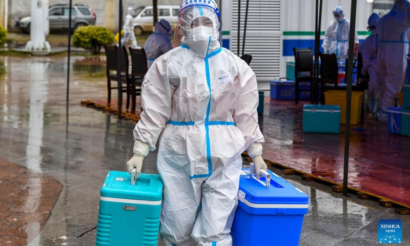 A medical worker transfers packages of COVID-19 nucleic acid testing samples in Debao County of Baise, south China's Guangxi Zhuang Autonomous Region, Feb. 13, 2022. In recent days, mobile laboratories and air-inflated laboratories have been put into use in order to improve the efficiency of COVID-19 nucleic acid testing in Debao County.(Photo: Xinhua)