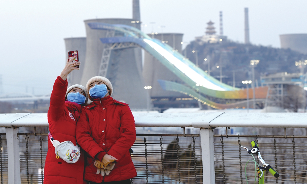 Tourists take a selfie with the Shougang Ski Jump Platform on February 10 on the New Shougang Bridge.Photo: cnsphoto 