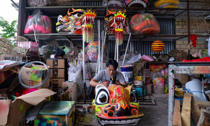 Craftsman Herdian colors a lion head for lion dance at Lily Hambali's workshop in Bogor, Indonesia on Feb. 14, 2022. (Photo: Xinhua)