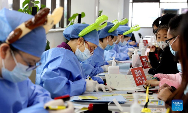 Medical workers wearing cartoon head decorations work at a vaccination site in Xuhui district of Shanghai on November 20, 2021. Photo: Xinhua