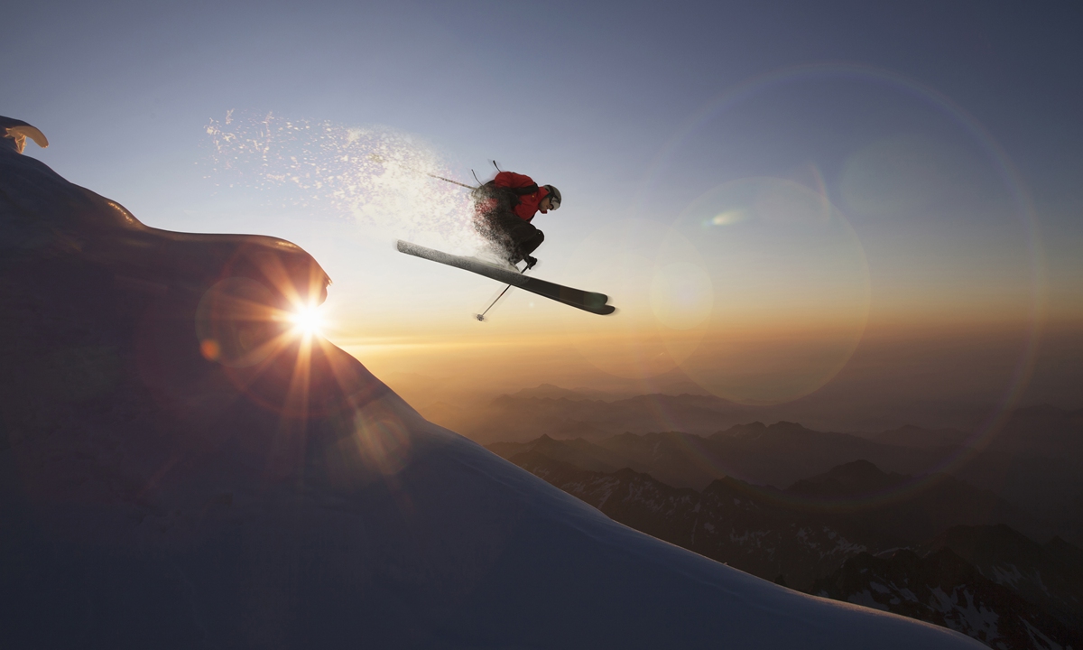 A skier jumping on a snowy slope at sunset, Zermatt, Canton Wallis, Switzerland Photo: VCG