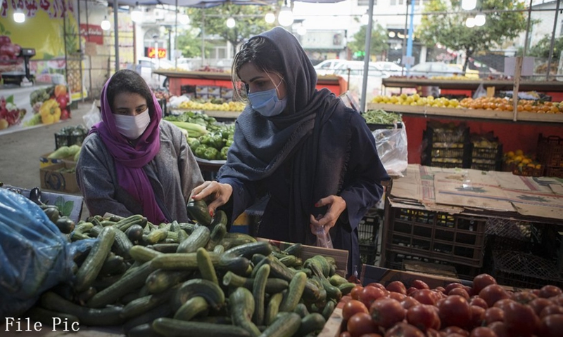 People wearing face masks buy food at a market in Tonekabon, Iran, Dec. 6, 2020.(Photo: Xinhua)