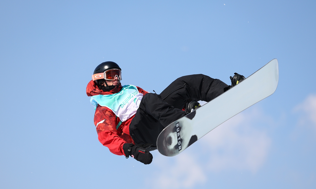Canadian snowboarder Mark McMorris performs a trick at Beijing 2022, with an image of the giant panda on his snowboard. Photo: VCG
