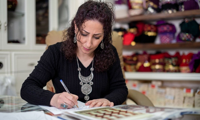 Palestinian fashion designer Khawla al-Tawil works at her store in the West Bank town of Beit Sahour on Feb. 9, 2022. (Photo: Xinhua)