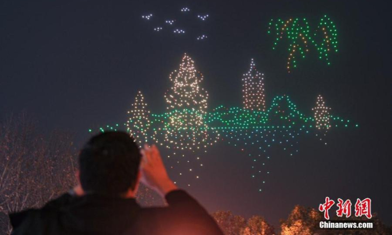 1000多架灯光无人机在西湖夜空中展示西湖风景区最著名的雷峰塔和三潭映月的图案，迎接第十九届亚运会倒计时200天。 2022年2月21日，中国东部浙江省省会杭州市。  （图片：中新社/王刚）