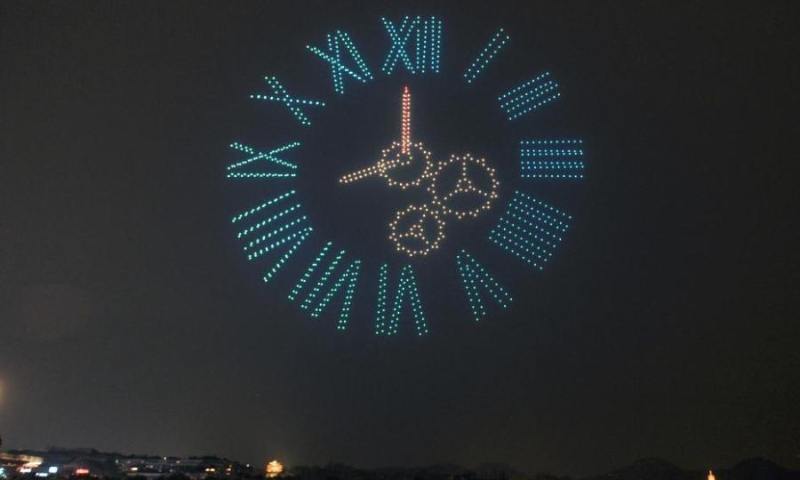 Over 1,000 illuminated drones display the pattern of a torch in the night sky above the West Lake to welcome the 200-day countdown to the 19th Asia Games in Hangzhou, capital city of east China's Zhejiang Province, Feb. 21,2022. (Photo: China News Service/Wang Gang)