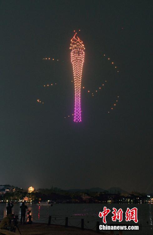 Over 1,000 illuminated drones display the pattern of a torch in the night sky above the West Lake to welcome the 200-day countdown to the 19th Asia Games in Hangzhou, capital city of east China's Zhejiang Province, Feb. 21,2022. (Photo: China News Service/Wang Gang)