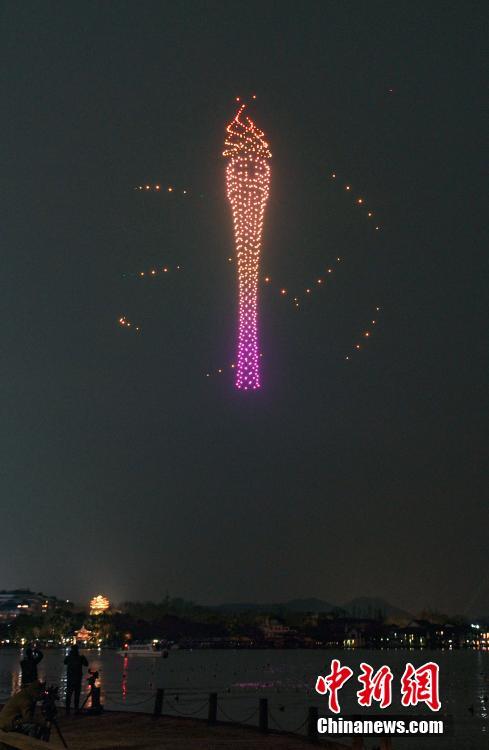 2022 年 2 月 21 日，在中国东部浙江省省会杭州市，1000 多架照明无人机在西湖上空的夜空中展示火炬图案，迎接第 19 届亚运会倒计时 200 天。  （图片：中新社/王刚）