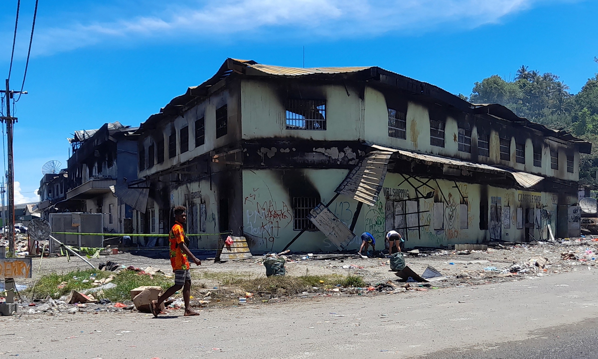 A man walks by ruins on November 28, 2021 after days of riots in Honiara, the Solomon Islands. Photo: AFP