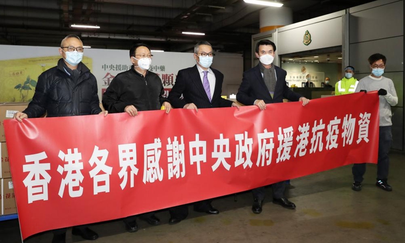 Edward Yau (4th L), secretary for commerce and economic development of the Hong Kong Special Administrative Region (HKSAR) government, poses for a group photo upon the arrival of the first batch of 150,000 boxes of anti-epidemic traditional Chinese medicines (TCM) donated by the Chinese mainland, as well as some other anti-epidemic supplies ordered previously, in south China's Hong Kong, Feb. 20, 2022.Photo:Xinhua